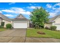 Charming single-story home featuring a well-manicured lawn, two-car garage, and a welcoming stone-lined entryway at 804 Harsworth Dr, Cary, NC 27519