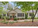 Charming two-story home with black shutters surrounded by lush greenery and a well-manicured lawn at 826 Rushing, Pittsboro, NC 27312