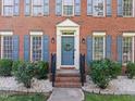 Elegant front door with a wreath, blue shutters, and manicured landscaping at 1013 New Chester Ct, Apex, NC 27502