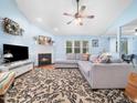 Inviting living room with a fireplace, ceiling fan, plush sectional sofa, and a large floral area rug at 102 Heritage Ridge Ct, Knightdale, NC 27545