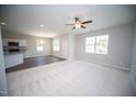 Bright living room with neutral colors, a ceiling fan, and large windows provide ample natural light and air flow at 109 Ambergate Ct, Rocky Mount, NC 27804