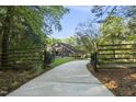 Gated driveway leads to a two-story home surrounded by lush trees at 13 Crosswinds Estates Dr, Pittsboro, NC 27312