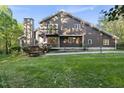 Two-story home featuring wood facade, balcony, and a stone chimney, with a manicured lawn at 13 Crosswinds Estates Dr, Pittsboro, NC 27312