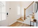 Bright entryway showcasing hardwood floors, a staircase with metal railings, and a stylish side table at 134 Cotten Dr, Morrisville, NC 27560