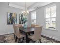 Elegant dining room with a modern chandelier, hardwood floors, and natural light from large windows at 1412 Main St, Lillington, NC 27546