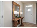 Inviting entryway featuring a wood-look console table with lamps and a large decorative mirror with wood frame at 1412 Main St, Lillington, NC 27546