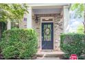 Close-up of a front door framed by green bushes and a brick facade at 1427 Van Page Blvd, Raleigh, NC 27607