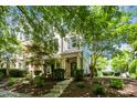 Beautifully landscaped townhouse with a welcoming front porch, surrounded by mature trees and manicured shrubs at 1427 Van Page Blvd, Raleigh, NC 27607