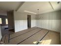 Bright dining room with elegant chandelier, wainscoting, and tray ceiling detail at 162 Tuskeegee Dr, Smithfield, NC 27577