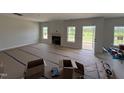 Bright living room with fireplace, complemented by large windows and a back patio door at 162 Tuskeegee Dr, Smithfield, NC 27577
