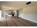 Open-concept living area leading to a kitchen with white cabinets and staircase access at 162 Tuskeegee Dr, Smithfield, NC 27577