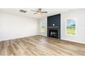 Bright living room featuring a ceiling fan, fireplace, and a large window at 162 Tuskeegee Dr, Smithfield, NC 27577