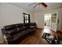 Spacious living room featuring hardwood floors, white walls, and a comfortable brown sectional sofa at 1620 Old Wilson Rd, Rocky Mount, NC 27801