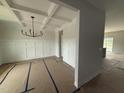 Bright dining room featuring decorative wainscoting, a modern light fixture, and an elegant coffered ceiling at 188 Tuskeegee Dr, Smithfield, NC 27577