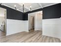 Elegant dining room with wainscoting, wood floors, coffered ceiling, and stylish light fixture at 188 Tuskeegee Dr, Smithfield, NC 27577
