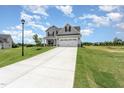 Well-manicured lawn with charming gray two-story home featuring an attached garage at 188 Tuskeegee Dr, Smithfield, NC 27577