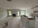 Unfinished kitchen and living area featuring a fireplace, an island, and white cabinets at 202 Tuskeegee Dr, Smithfield, NC 27577
