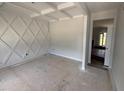 Bright, unfinished living room showcasing decorative wall and ceiling trim and an open doorway with views of the home at 202 Tuskeegee Dr, Smithfield, NC 27577