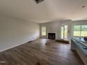 Spacious living room featuring wood floors, fireplace, large windows and doors with views of the backyard at 202 Tuskeegee Dr, Smithfield, NC 27577