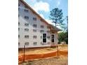Exterior home under construction with visible wood framing and windows against a partly cloudy sky at 219 Crescent Dr, Dunn, NC 28334