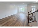 Bright living room with wood floors, natural light, and staircase at 2403 Whitewing Ln, Wendell, NC 27591