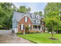 Charming brick two-story home featuring a well-manicured lawn, dormers, and a welcoming front porch at 244 Mantle Dr, Clayton, NC 27527
