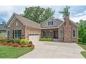A stone and siding home boasts a two-car garage, covered entryway and well-maintained landscaping at 2633 Beckwith Rd, Apex, NC 27523