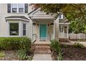 Charming front porch featuring brick steps, a bright teal door, and decorative hanging plants at 2705 Kempsford Pl, Raleigh, NC 27604
