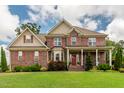 Charming two-story brick home featuring a covered porch and a manicured front yard at 2912 Turning Brook Ln, Raleigh, NC 27616