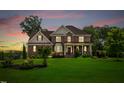 Lovely brick home with a manicured lawn, featuring red shutters and a welcoming front porch at sunset at 2912 Turning Brook Ln, Raleigh, NC 27616