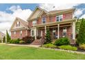 Beautiful brick two-story home with red shutters, covered front porch, and manicured landscaping at 2912 Turning Brook Ln, Raleigh, NC 27616