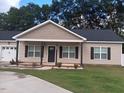 Charming single-story home with a well-manicured lawn and inviting front porch and long concrete driveway at 31 Kevior Ave, Four Oaks, NC 27524