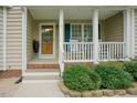 Inviting front porch featuring rocking chairs, blue shutters, and a decorative glass front door at 318 Tillamook Dr, Wake Forest, NC 27587