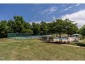 Resort-style pool and tennis court surrounded by lush greenery; perfect for outdoor leisure and recreation at 4038 Carpenter Pond Rd, Durham, NC 27703