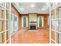 Bright living room featuring wood paneled walls, a brick fireplace, and multiple skylights for natural lighting at 407 W Sixth St, Siler City, NC 27344