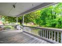 View from the porch with white railings and lush green trees at 407 W Sixth St, Siler City, NC 27344