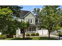 Two-story home with inviting porch, well-manicured lawn, and attached garage, ideal for comfortable living at 436 Edgepine Dr, Holly Springs, NC 27540