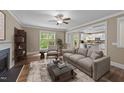 Comfortable living room with a fireplace, a modern sofa, and an open view into the bright kitchen at 436 Edgepine Dr, Holly Springs, NC 27540