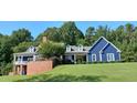 Beautiful two-story home with manicured lawn, covered porch, and brick retaining wall at 4874 Thom Rd, Mebane, NC 27302