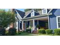Inviting covered porch with rocking chairs and well-maintained landscaping at 4874 Thom Rd, Mebane, NC 27302