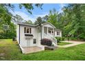 Exterior shot of the home showcasing brick, a cozy porch, manicured shrubs, and a well-maintained lawn at 5020 Mimosa Dr, Durham, NC 27713