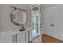 Stylish foyer with a round mirror, marble-topped console table, and hardwood floors at 511 Hamilton Cottage Way, Raleigh, NC 27605