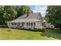 Inviting home featuring a classic white exterior, wraparound porch, and manicured lawn at 5308 Stableview Ct, Holly Springs, NC 27540
