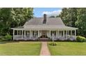 Inviting front porch featuring a brick walkway, manicured lawn, and a charming facade that welcomes you home at 5308 Stableview Ct, Holly Springs, NC 27540