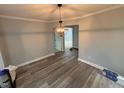 The dining room has light gray walls, wood-look flooring, white trim and a modern chandelier at 65 Prospect Church Rd, Erwin, NC 28339