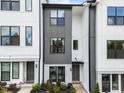Contemporary townhome boasts a mix of gray and white siding, complemented by dark windows and fresh landscaping at 710 W North St # 103, Raleigh, NC 27603