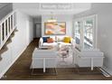 Bright, staged living room featuring modern furniture, hardwood floors, and a large window for plenty of natural light at 720 Rawls Dr, Raleigh, NC 27610