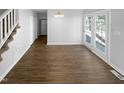 Open floor plan with hardwood floors, leading to a staircase and featuring a glass door with a view to outside at 720 Rawls Dr, Raleigh, NC 27610
