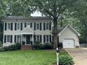 Charming two-story home with a well-manicured front lawn, mature trees, and a classic colonial design at 7517 Chippenham Ct, Raleigh, NC 27613