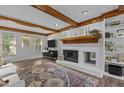 Inviting living room with wood beams, fireplace, and built-in shelving perfect for cozy evenings at 7517 Chippenham Ct, Raleigh, NC 27613
